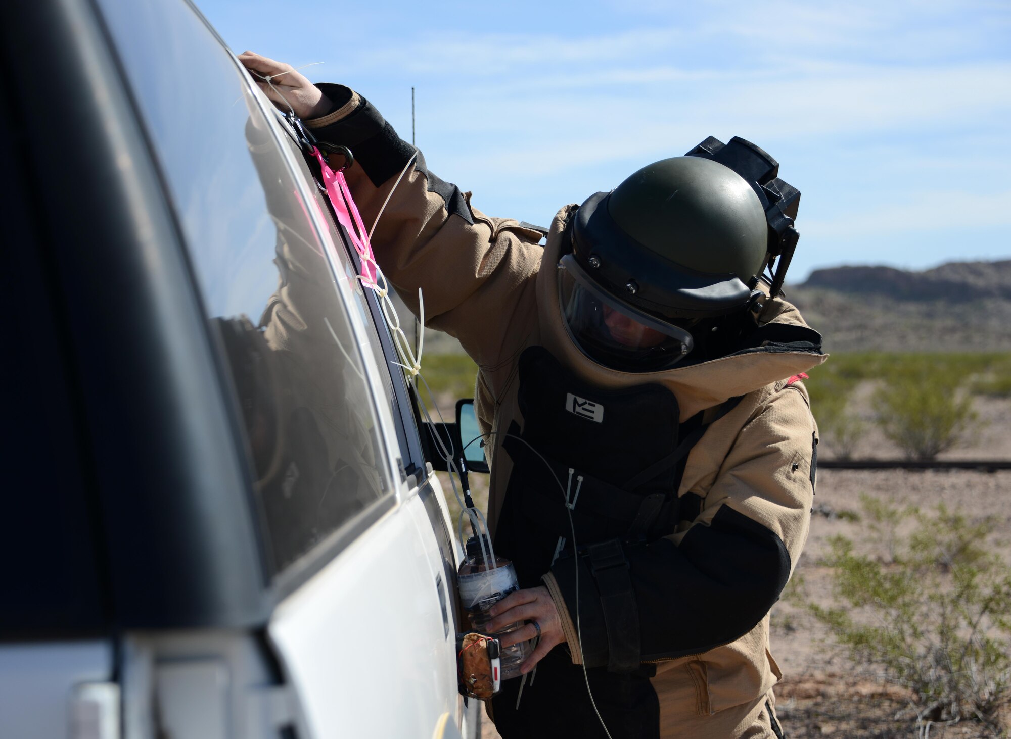 Staff Sgt. Timothy Doland, 56th Civil Engineer Squadron explosive ordnance disposal team leader, places a water bottle charge on the side of a vehicle during a contingency problem Feb. 8, 2017, at the Barry M. Goldwater Range in Gila Bend, Az. Throughout the exercise, EOD Airmen were challenged with various contingency problems in which they had to detect, defuse, and destroy potential roadside bomb threats. (U.S. Air Force photo by Airman 1st Class Alexander Cook)