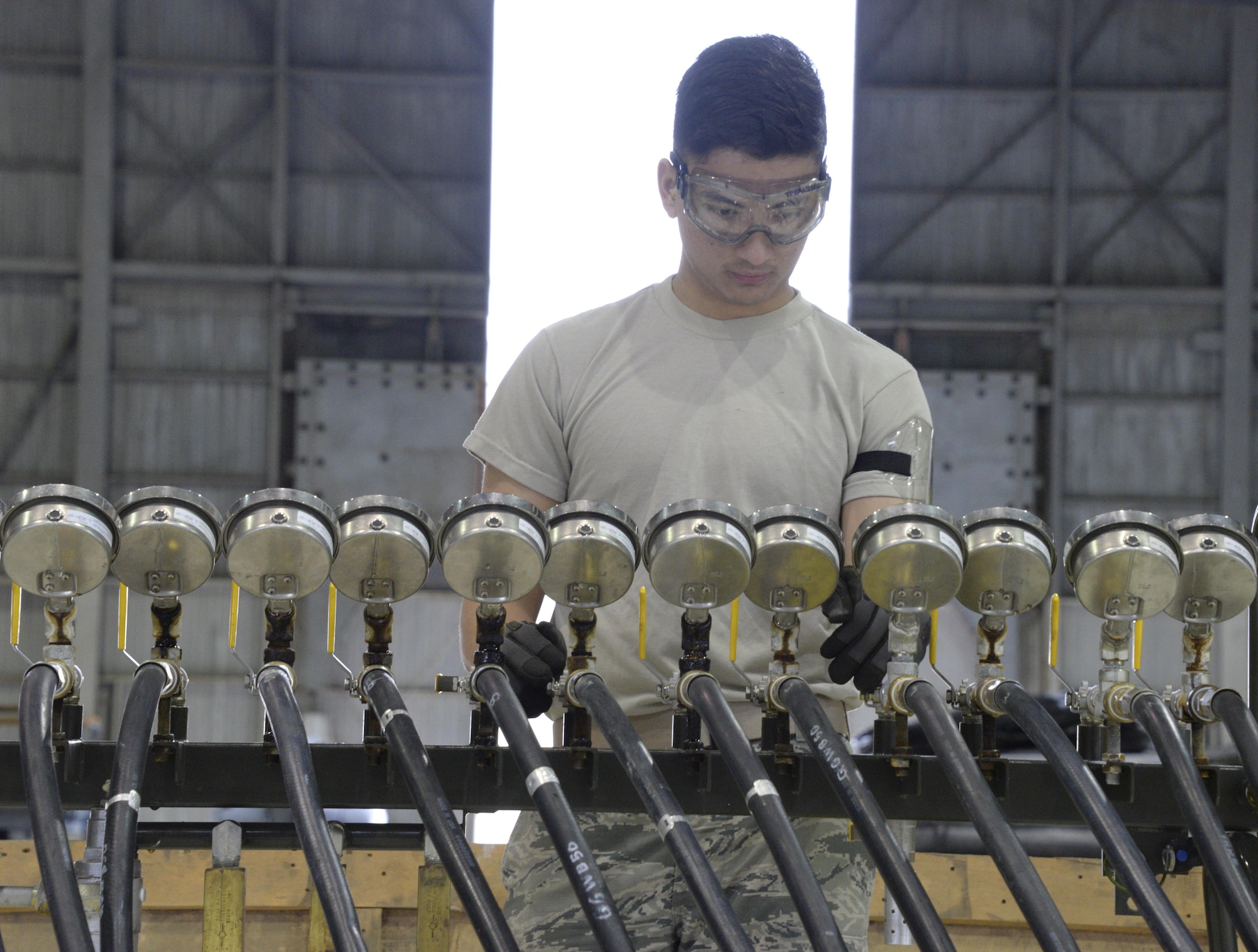 An Airman from the 60th Maintenance Squadron monitors the pounds per square inch while inflating lifting bags during an annual quality assurance inspection of the crash, damaged or disabled aircraft recovery program Feb. 9, 2017 at Travis Air Force Base, Calif. The lifting bags, filled to 7 PSI during the inspection, are used to lift a downed aircraft so it can be salvaged, repaired and recovered.  (U.S. Air Force photo by Senior Airman Amber Carter)