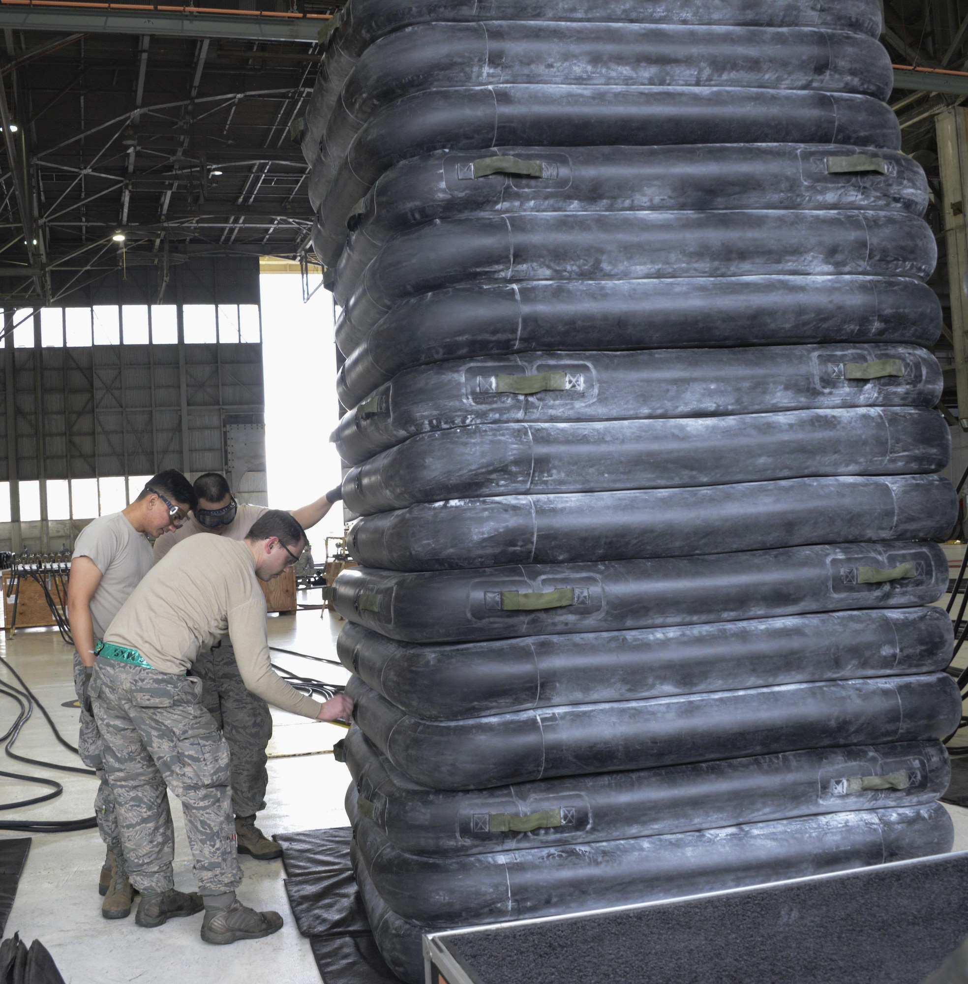 Airmen from the 60th Maintenance Squadron inspect large lifting bags for leaks during an annual quality assurance inspection of the crash, damaged or disabled aircraft recovery program Feb. 9, 2017 at Travis Air Force Base, Calif. The lifting bags, capable of supporting up to 52,000 pounds individually, are used to lift a downed aircraft so it can be salvaged, repaired and recovered.  (U.S. Air Force photo by Senior Airman Amber Carter)