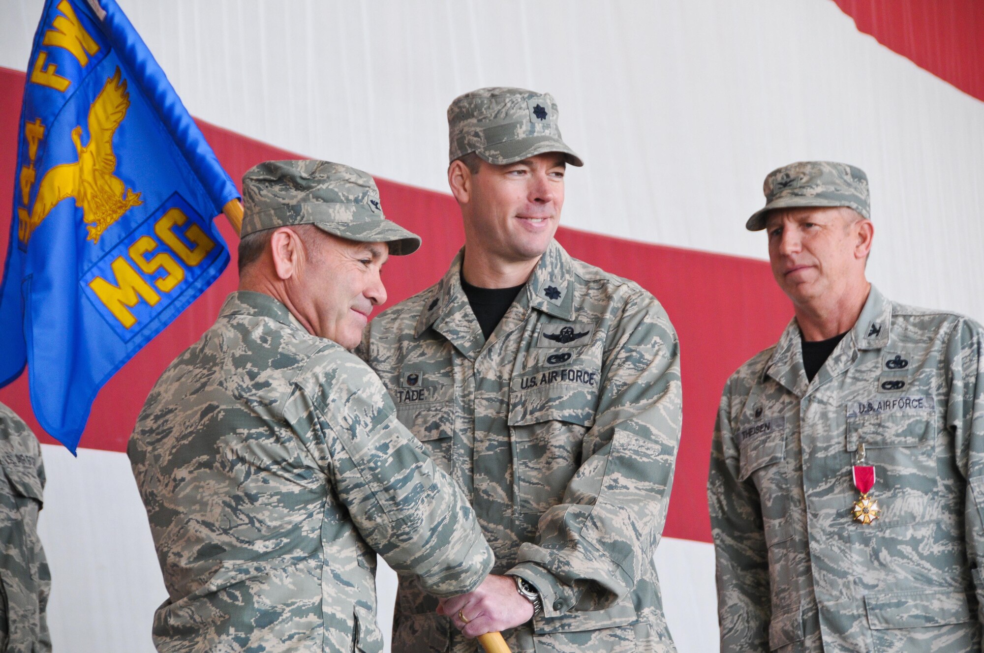 Col. Kurt J. Gallegos, 944th Fighter Wing commander, hands the 944th Mission Support Group guidon to Lt. Col. Gavin D. Tade, 944 MSG commander, Feb. 12 during a change-of-command ceremony held at Luke Air Force Base, Ariz. (U.S. Air Force photo by Staff Sgt. Nestor Cruz.)