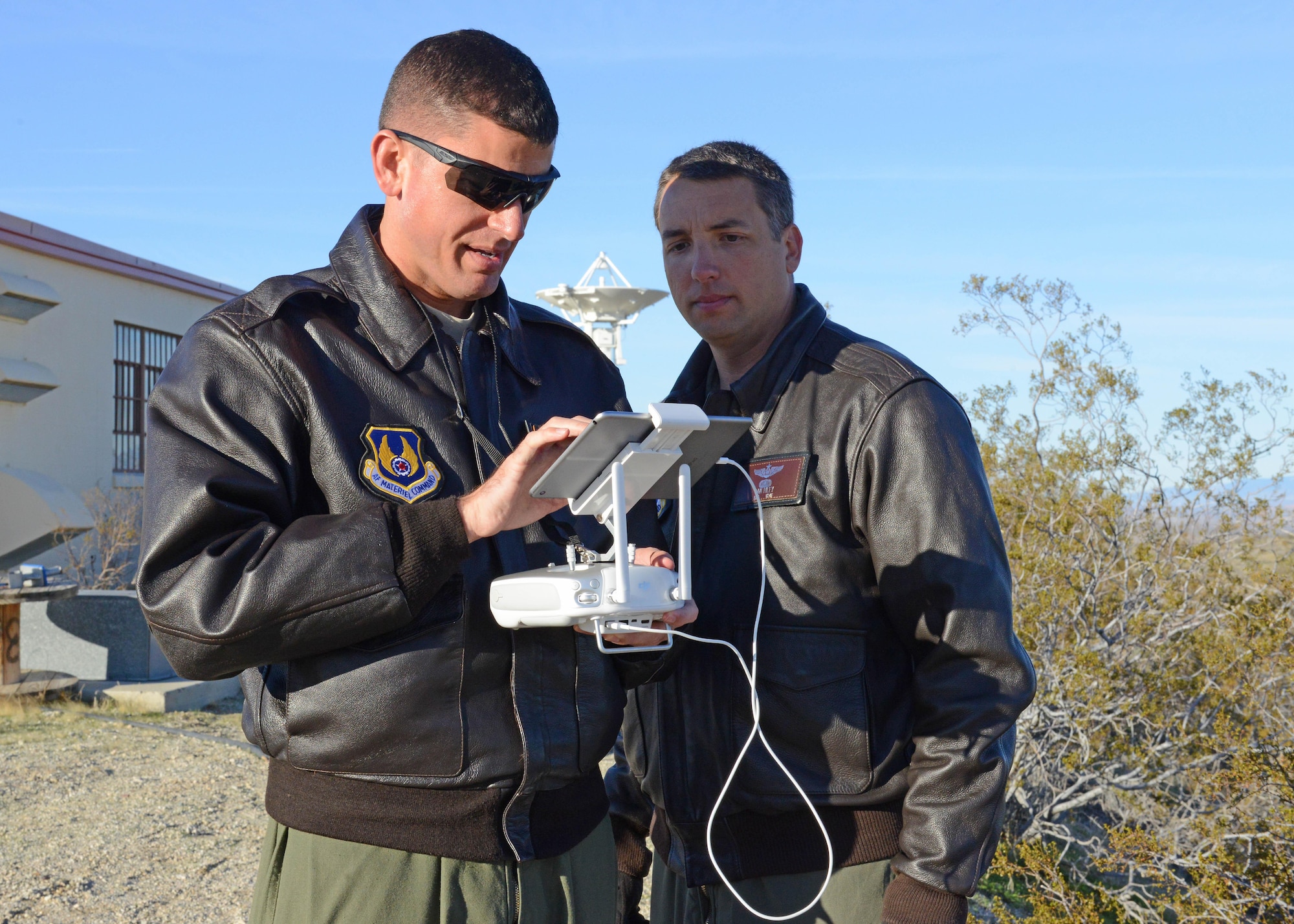 Maj. William Niblack, Emerging Technologies Combined Test Force, operations officer (left), pilots a quadcopter on the second test sortie Feb. 13. Maj. Danny Riley, ET CTF director (right) piloted the third and final sortie. The test was conducted to see if it’s possible to use a small unmanned aerial system to calibrate Edwards AFB’s telemetry antennas. (U.S. Air Force photo by Kenji Thuloweit)