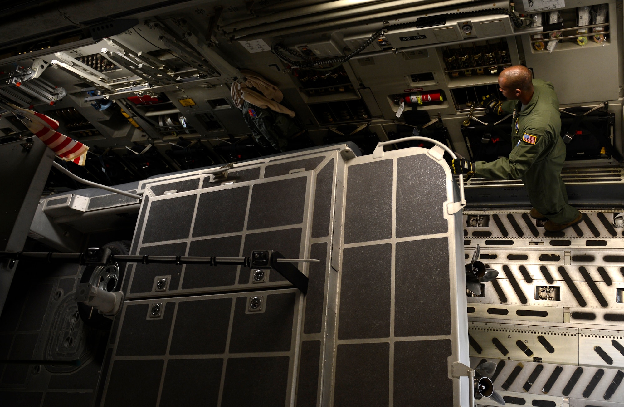 U.S. Air Force Senior Airman Andre Phillip, 732nd Airlift Squadron loadmaster, assigned to Joint Base McGuire-Dix-Lakehurst, N.J., signals the movement of a security boat on to a C-17 Globemaster III at Joint Base Langley-Eustis, Va., Feb. 8, 2017. Airmen from both Air Force bases and U.S. Coast Guardsmen worked together to load boats and a large equipment pallet on to the aircraft. (U.S. Air Force photo by U.S. Airman 1st Class Kaylee Dubois)