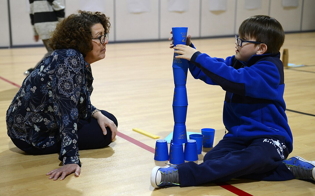 Pandora Howell, 733rd Civil Engineer Division portfolio optimization chief, provides guidance as Ralph Belford, VI, age eight, son of U.S. Army Sgt. 1st Class Ralph Belford, V, Army Training Support Center NCO, builds a tower during the Family science, technology, engineering and mathematics Night event at Gen. Stanford Elementary School at Joint Base Langley-Eustis, Va., Feb. 9, 2017. Architectural and design professionals attended the event to help students understand how math, height and stability work together when building tall towers. (U.S. Air Force photo by Staff Sgt. Teresa J. Cleveland)