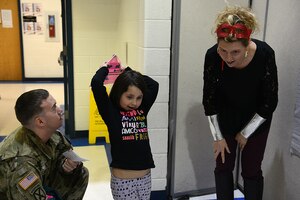 Kyleigh Johnson, age five, prepares to throw a glider she built as her father, U.S. Army Staff Sgt. Robert Johnson, Bravo Company, 2nd Battalion, 210th Aviation Regiment, 128th Aviation Brigade instructor, and April Dawson, Gen. Stanford Elementary School 4th grade teacher, cheer and watch during the Family science, technology, engineering and mathematics Night event at Joint Base Langley-Eustis, Va., Feb. 9, 2017.  Teachers and JBLE volunteers used engineering, design, architecture, mathematics and computer technology to educate students on how STEM principles tie into military careers for search and rescue teams, transportation engineers, computer programming, musicians and architects. (U.S. Air Force photo by Staff Sgt. Teresa J. Cleveland)