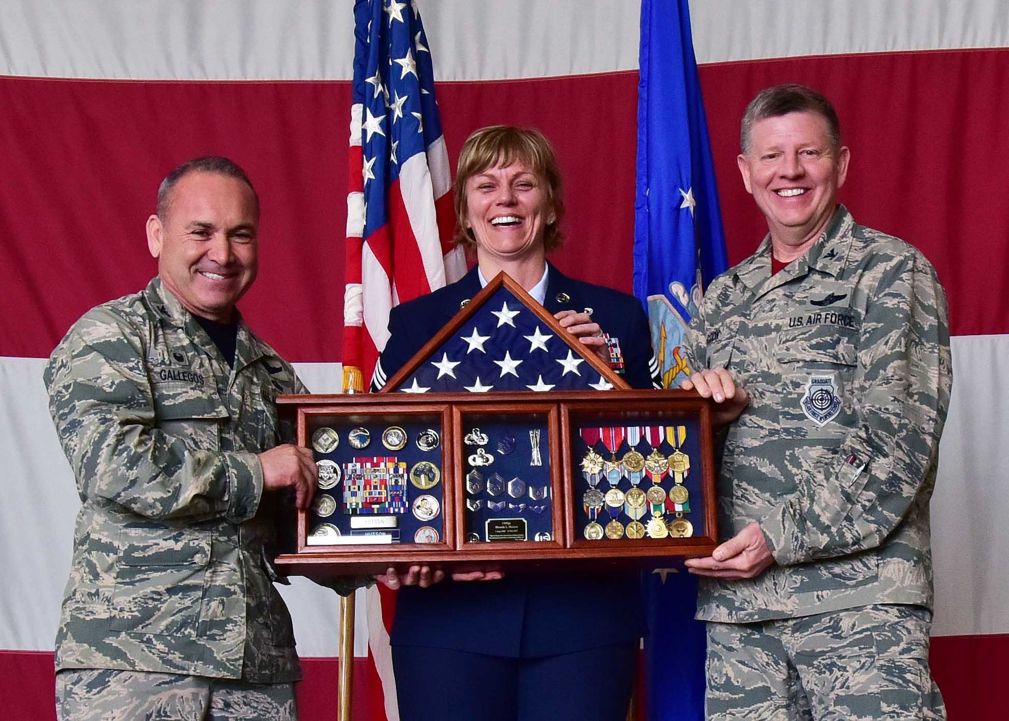 Col. Kurt Gallegos and Col. Bryan Cook, 944th Fighter Wing commander and vice commander, present a shadow box to Chief Master Sgt. Rhonda Hutson, 944 FW command chief, Feb. 12 during her retirement ceremony held at Luke Air Force Base, Ariz. (U.S. Air Force photo by Tech. Sgt. Louis Vega Jr.)