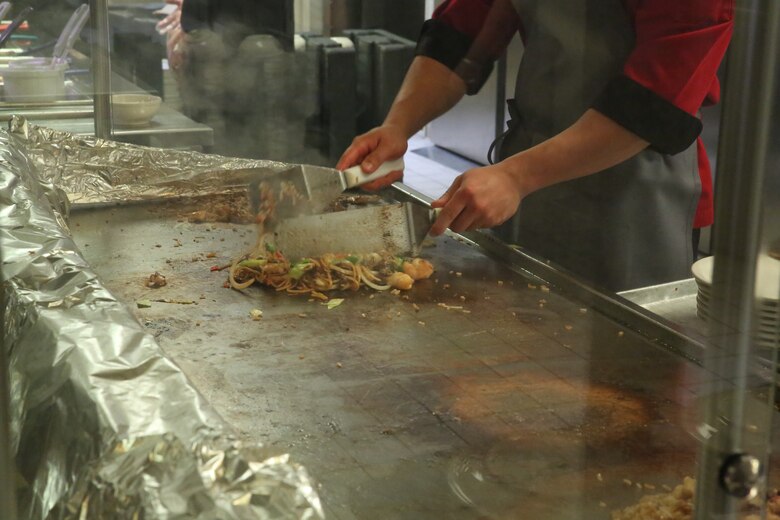 A food service specialist cooks Mongolian entrée selections on the grill during Mongolian Bar Wednesday in the R.G. Robinson Mess Hall at Marine Corps Air Station Iwakuni, Japan, Feb. 8, 2017. Mongolian Bar Wednesday was started in an effort to attract more patrons to the mess halls by offering specialty meals such as the Mongolian Bowl. (U.S. Marine Corps photo by Lance Cpl. Carlos Jimenez.)