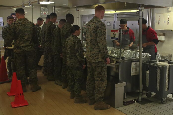 U.S. Marines wait in line while food service specialists sauté Mongolian entrée selections on the grill during Mongolian Bar Wednesday in the R.G. Robinson Mess Hall at Marine Corps Air Station Iwakuni, Japan, Feb. 8, 2017. Mongolian Bar Wednesday was started in an effort to attract more patrons to the mess halls by offering specialty meals such as the Mongolian Bowl. (U.S. Marine Corps photo by Lance Cpl. Carlos Jimenez.)