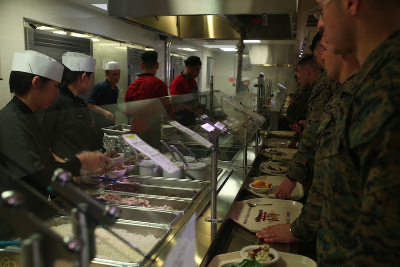 U.S. Marines wait in line while the food service division specialists sauté their Mongolian entrée selections on the grill during Mongolian Bar Wednesday in the R.G. Robinson Mess Hall at Marine Corps Air Station Iwakuni, Japan, Feb. 8, 2017. Mongolian Bar Wednesday was started in an effort to attract more patrons to the mess halls by offering specialty meals such as the Mongolian Bowl. (U.S. Marine Corps photo by Lance Cpl. Carlos Jimenez.)