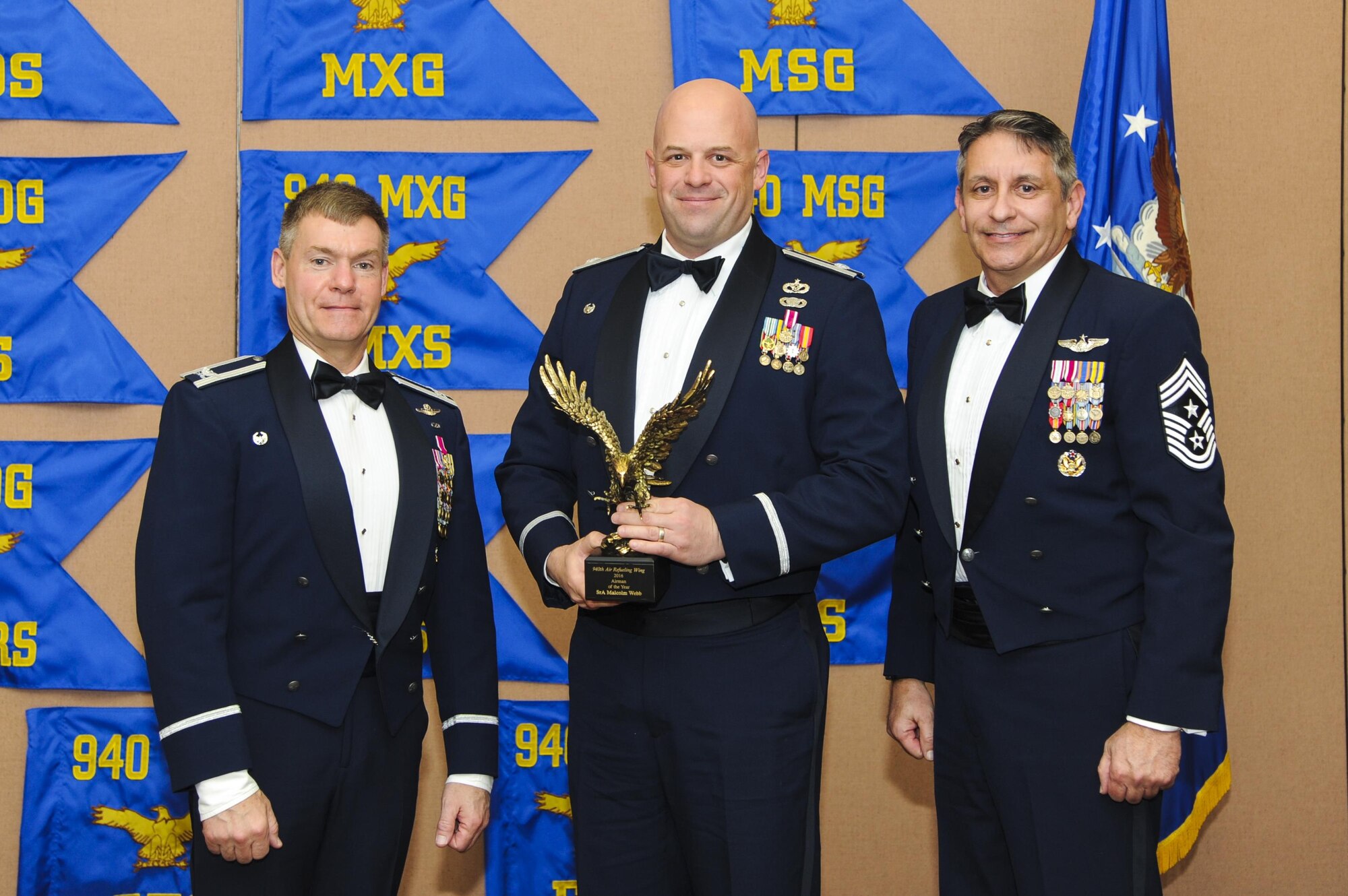 Lt. Col. Bradley King, 940th Civil Engineer Squadron commander, accepts the Airman of the Year award on behalf of recently promotoed Staff Sgt. Malcolm Webb, 940 CES fire team member, presented by Col. Craig C. Peters, 940th Air Refueling Wing commander, and Chief Master Sgt. Carmen Madia, 940 ARW command chief Feb. 11, 2017 at Beale Air Force Base, California. Webb was unable to attend the ceremony. (U.S. Air Force by Senior Airman Tara R. Abrahams)