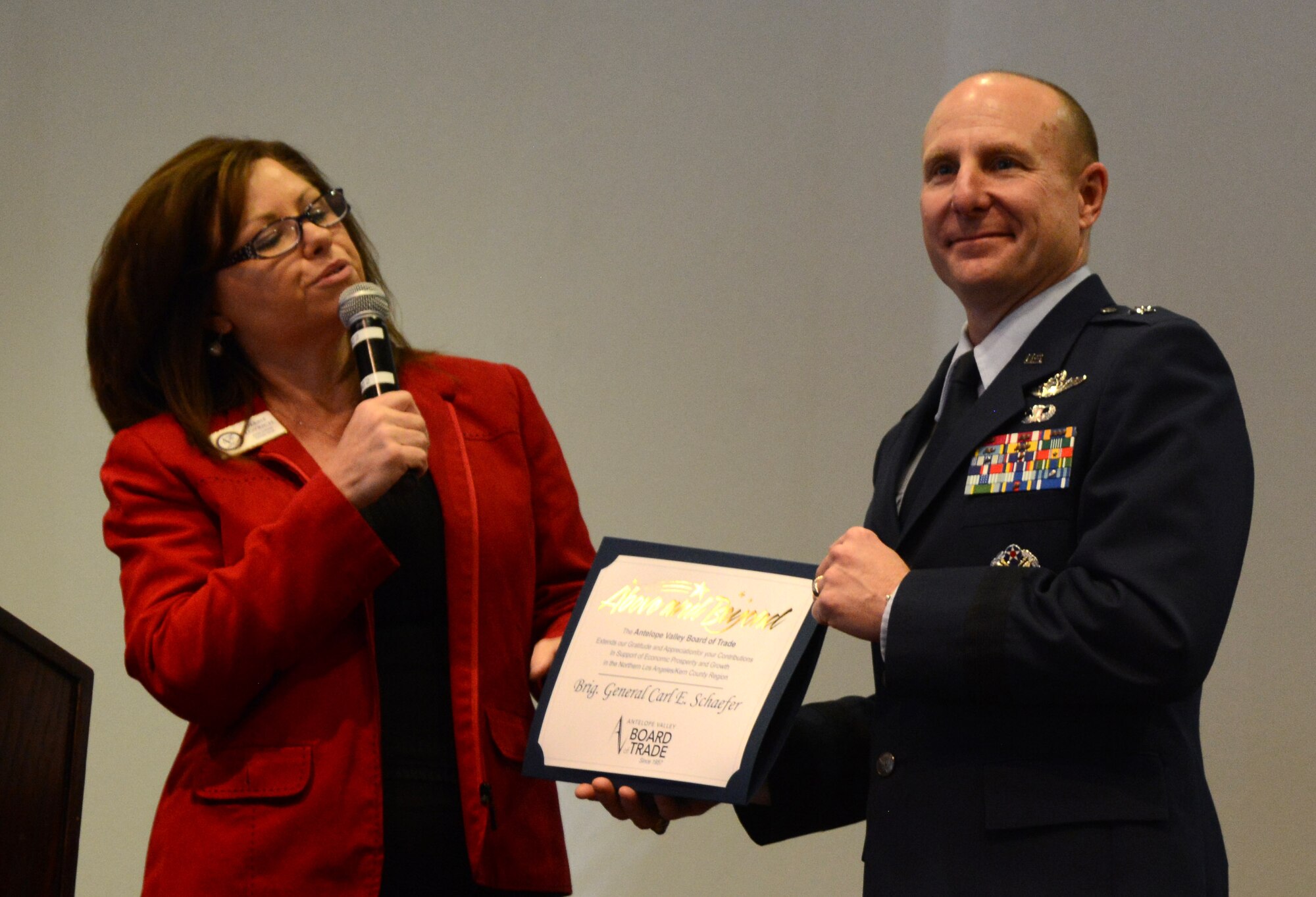 Debbie Lovrich, Executive Director of the Antelope Valley Board of Trade, presents Brig. Gen. Carl Schaefer, 412th Test Wing commander, with an award to thank him for speaking at the luncheon, “and also a sincere appreciation for his influence on the economic growth and prosperity in the Northern Los Angeles and Kern County Region.” (U.S. Air Force photo by Christopher Ball)