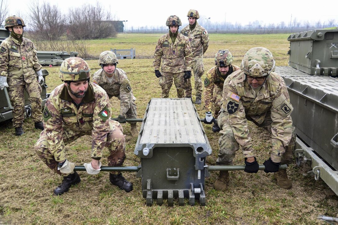 U.S. and Italian soldiers assemble a girder bridge near Rovigo, Italy, Feb. 13, 2017. A crew can assemble the bridge, which provides a wide roadway, with minimal support. The U.S. soldiers are paratroopers assigned to the 173rd Airborne Brigade, 54th Brigade Engineer Battalion. Photo by Graigg Faggionato
