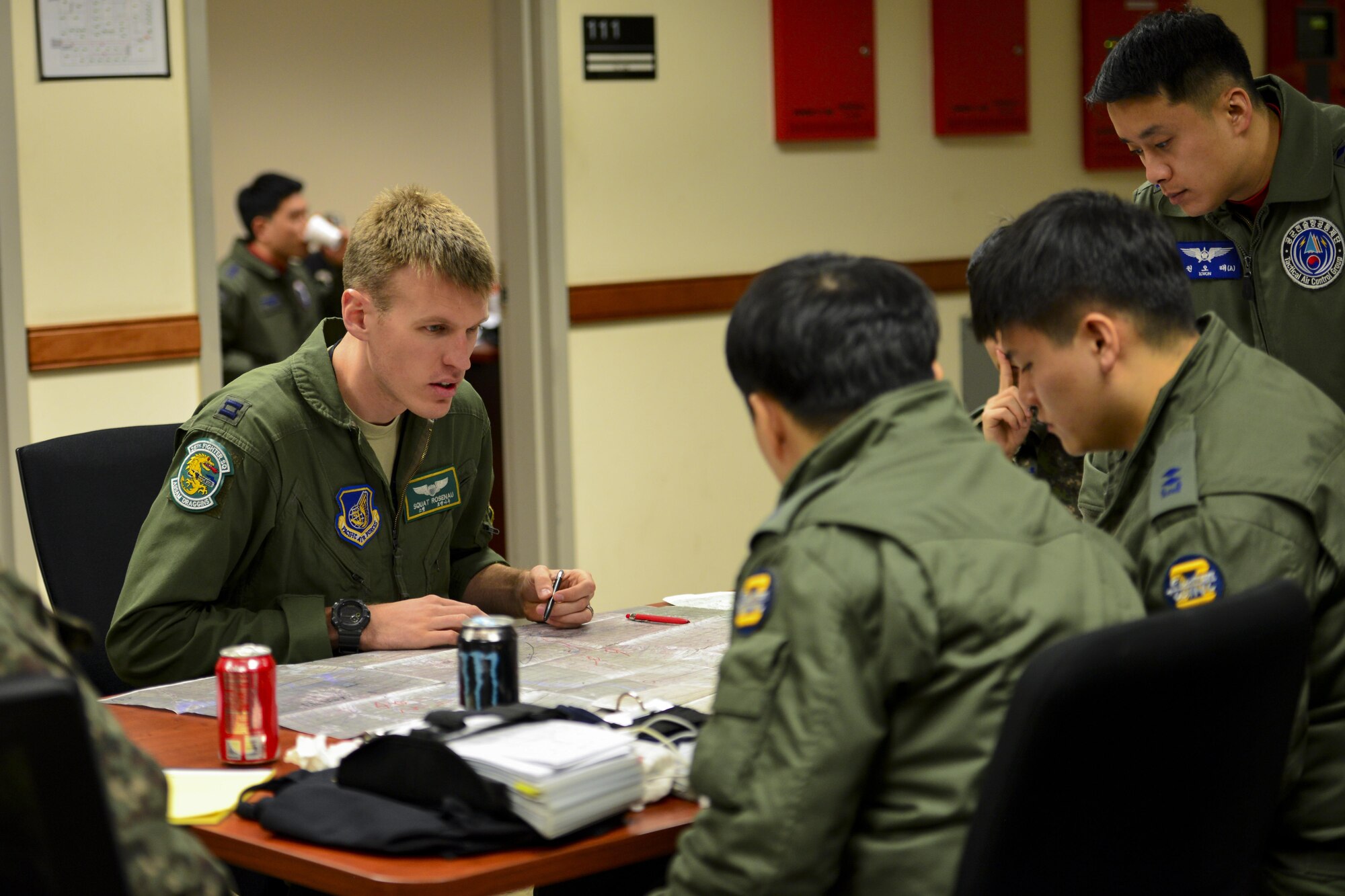 U.S. Air Force Capt. James Rosenau, 25th Fighter Squadron pilot, discusses a flight plan with Republic of Korea air force personnel during Buddy Wing 17-3 at Osan Air Base, ROK, Feb. 14, 2017. Buddy Wing exercises are held throughout the year at different air bases across the ROK, bringing together different elements of U.S. and ROK air force assets for bi-lateral training and the exchange of skills. (U.S. Air Force photo by Staff Sgt. Victor J. Caputo)