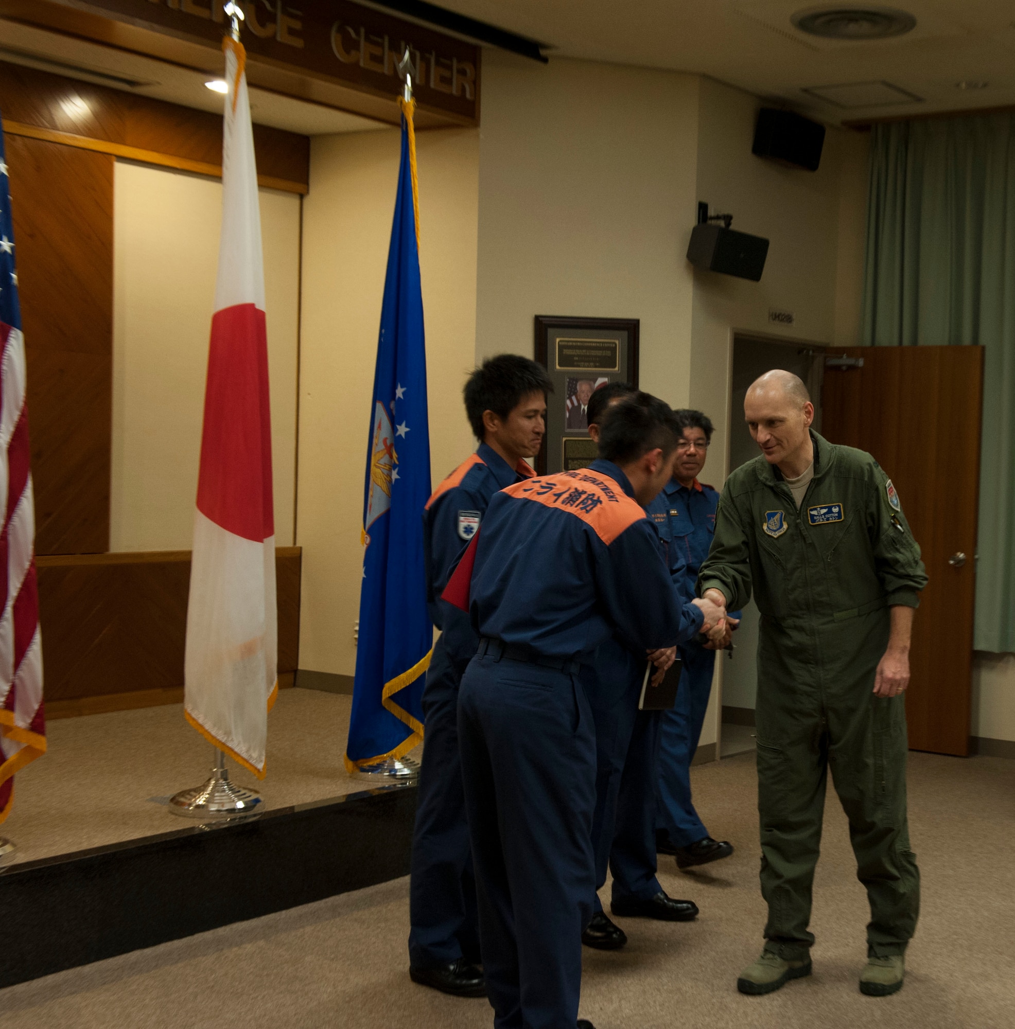 U.S. Air Force Col. John Cotton, 18th Aerospace Medicine Squadron commander, shakes hands with Nirai Fire Department members Feb. 13, 2017, at Kadena Air Base, Japan. Cotton and the Nirai Fire Department members worked together to save the life of a local woman Feb. 3 when she was struck by a car while riding her bicycle. (U.S. Air Force photo by Senior Airman Lynette M. Rolen/Released)