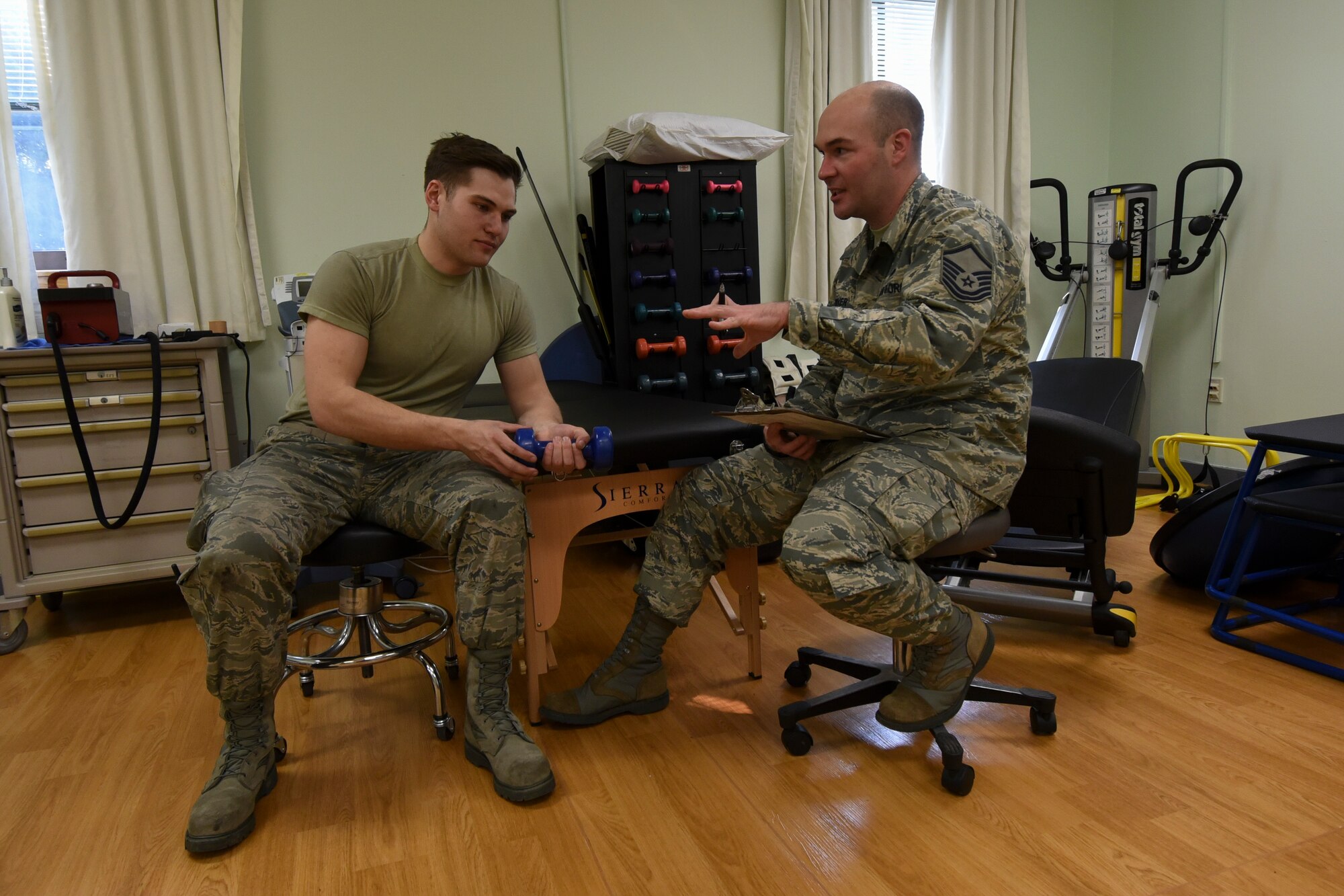 U.S. Air Force Master Sgt. Gregory Dorner, 8th Medical Operations Squadron Physical Therapy flight chief, talks with Senior Airman Tyler Macmillan, 8th Logistics Readiness Squadron Material Handling Equipment maintenance journeyman, about his treatment progress while performing wrist exercises during a physical therapy appointment at Kunsan Air Base, Republic of Korea, Feb. 13, 2017. The physical therapy section is responsible for ensuring proper healing and rehabilitation of Airmen who have injuries or are recovering from surgeries. Once approved through their primary care manager, Airmen can make an appointment to visit the physical therapy section to ensure they are in the best shape to perform their duties. (U.S. Air Force photo by Senior Airman Michael Hunsaker/Released)