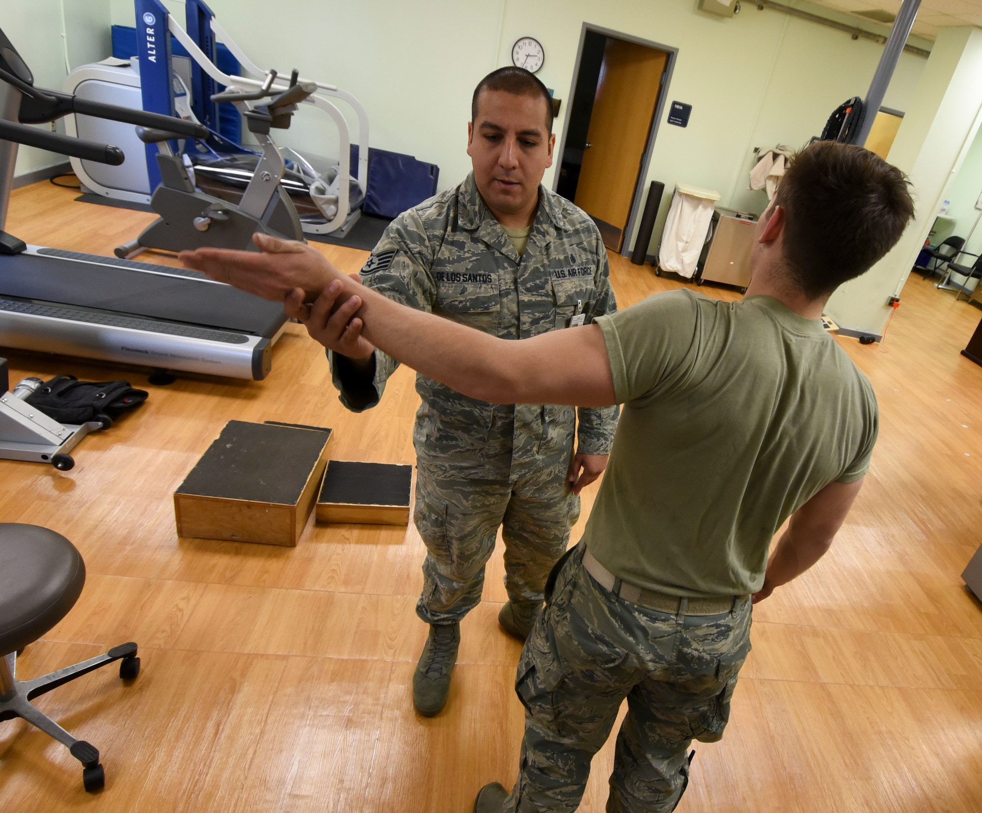 U.S. Air Force Staff Sgt. Pedro De Los Santos, 8th Medical Operations Squadron Physical Therapy noncommissioned officer in charge, assists Senior Airman Tyler Macmillan, 8th Logistics Readiness Squadron Material Handling Equipment maintenance journeyman, with elbow mobilization and nerve glide exercises during a physical therapy appointment at Kunsan Air Base, Republic of Korea, Feb. 13, 2017. De Los Santos ensures proper movement and function through rehabilitation of Macmillan’s arm, which was injured while lifting weights at the gym. (U.S. Air Force photo by Senior Airman Michael Hunsaker/Released)
