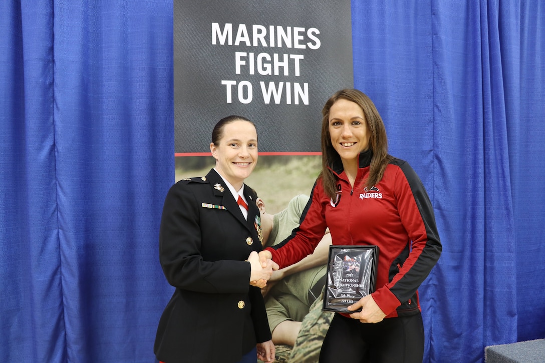 Former wrestler, Maj. Jill McQuistan, presents an award to Marine veteran, Kalyn Schwartz, Feb. 10-11, at the Women’s Collegiate Wrestling Association National Championships in Oklahoma City. Marine Corps Recruiting Command’s marketing relationship with USA Wrestling is focused on locating and recruiting physically and mentally well-equipped young men and women who share the same values of honor, courage and commitment. (U.S. Marine Corps photo by Cpl. Jennifer Webster/Released)
