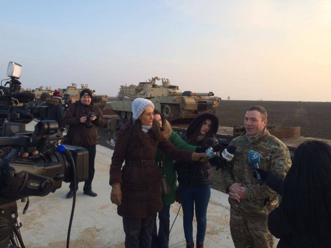 Army Maj. Scott Stephens, executive officer, 1st Battalion, 8th Infantry Regiment, fields questions from Romanian journalists at the arrival of the first 15 tanks to Mihail Kogalniceanu Airbase, Romania, Feb. 14, 2014. The arrival of the tanks and roughly 500 soldiers from 1st Battalion, 8th Infantry Regiment, marks the beginning of a continuous rotation of U.S. troops in southeastern Europe as part of Operation Atlantic Resolve. Army photo by 2nd Lt. Gunbold Ligden