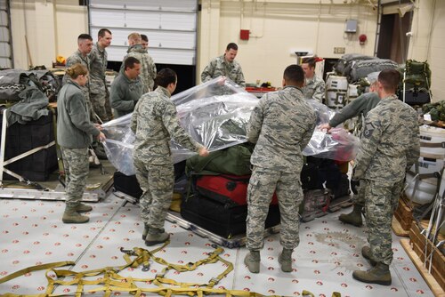 Members of the 120th Airlift Wing Medical Group and Small Air Terminal wrap a baggage pallet in preparation for loading on a C-130 Hercules aircraft at Great Falls International Airport Sunday. Guardsmen will be attending medical readiness training in Anniston, Ala. (U.S. Air National Guard photo by Master Sgt. Michael Touchette)