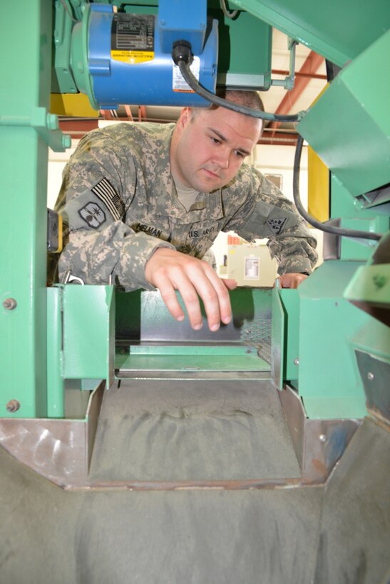 Army Spc. Zackary T. Helman, an ammunition stock control and accounting specialist with the 371st Sustainment Brigade, inspects an Automated Tactical Ammunition Classification System at Camp Arifjan, Kuwait, Jan. 14, 2014. In one hour the ATACS, developed by Cybernet Systems Corporation, can inspect and sort up to 5,000 rounds of mixed ammunition ranging from 5.56 mm to .50-caliber. Army photo by Sgt. John Carkeet IV
