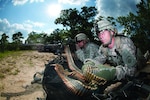 Army Spc. Robert Woodworth feeds ammunition to Army Spc. John Thrasher’s M240B machine gun as the two help to provide covering fire for their platoon during the assault on an enemy position that was part of a war-game exercise held at Fort Bragg, N.C., May 4, 2011. The Army’s ammunition community will benefit from a new, improved automated information system that is more secure, transparent and user-friendly. Army photo by Terrance Bell