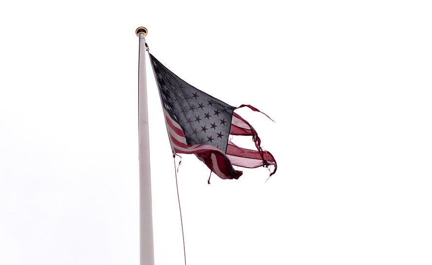 A tattered U.S. flag waves over the World War II air field located at Nuthampstead, England, on Jan. 1, 2017. Local area residents ensure that the U.S. flag remains on the flagpole out of respect and remembrance. (U.S. Air Force photo by Josh Plueger)