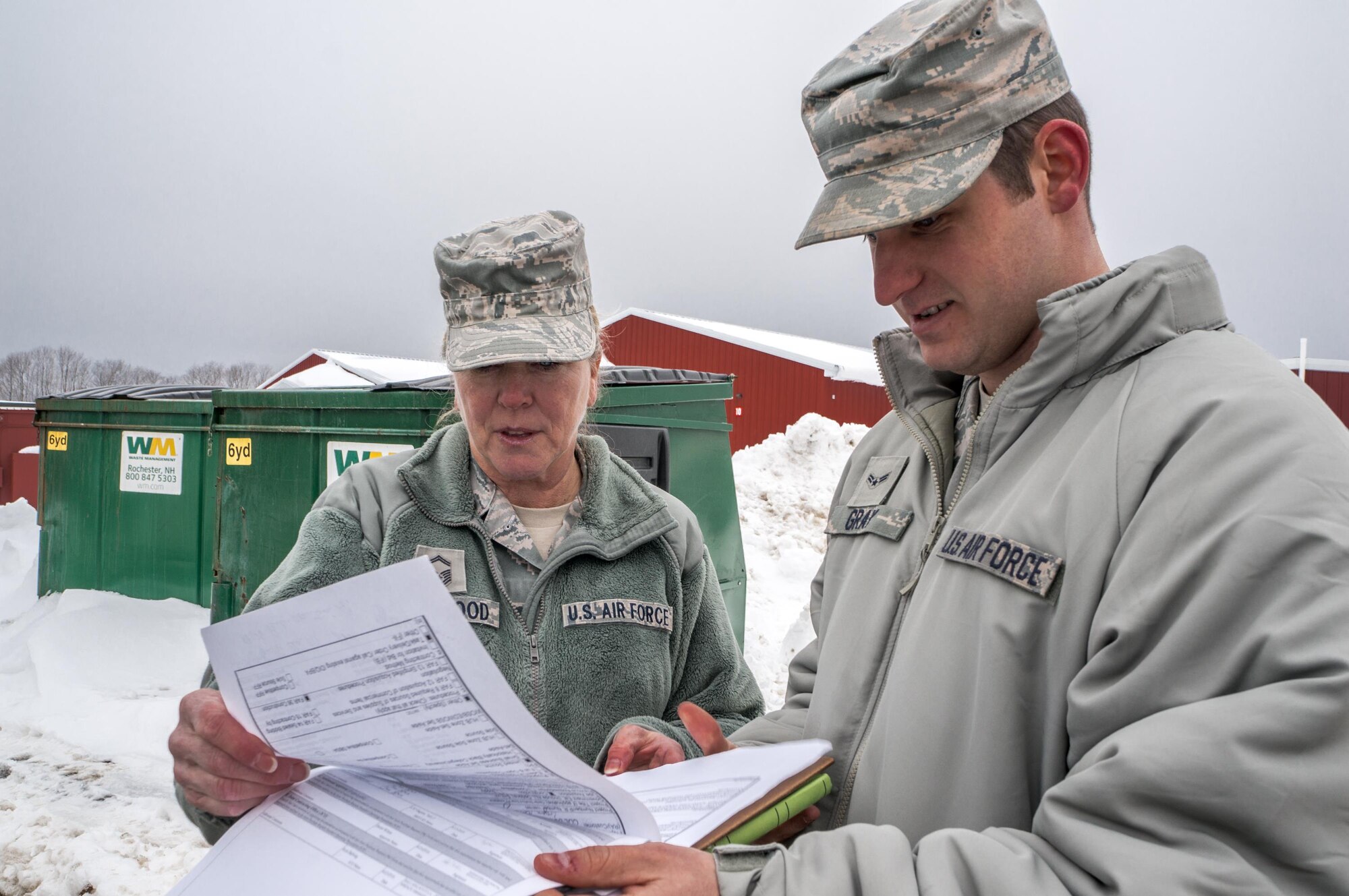 Senior Master Sgt. Regina Rockwood, 157th Mission Support Group superintendent, left, and Airman 1st Class Philip Gray, 22nd Contracting Squadron contract administrator, review site visit details, Feb. 16, 2017, at Pease Air Force Base, New Hampshire.  Contract Airmen solicit and award contracts, work with local contractors for construction projects and ensure the government is getting the best value possible. (Courtesy photo)