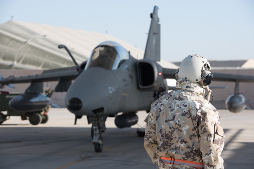 An Italian air force maintainer watches while Air Force Lt. Col. Joe “Slap” Goldsworthy, a pilot assigned to the Italian air force 132nd Groupo as part of the Military Personnel Exchange Program, prepares to taxi in an AMX A-11 Ghibli aircraft at an undisclosed location in Southwest Asia, Jan. 11, 2017. Goldsworthy has served with the Italian air force for nearly three years as a fully integrated member of the 132nd Groupo. Air Force photo by Master Sgt. Benjamin Wilson