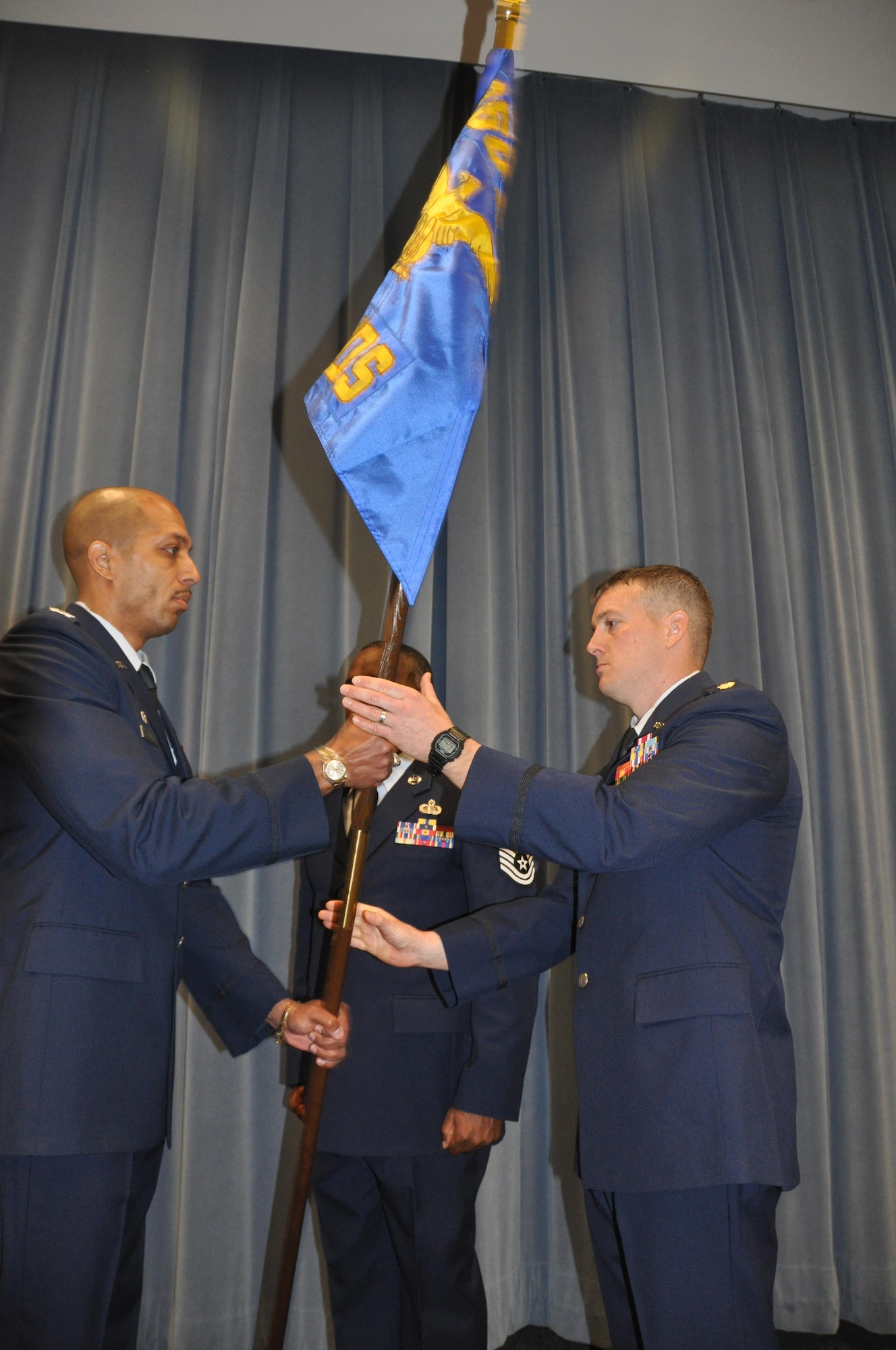Commander of the 960th Cyberspace Operations Group, Col. Anthony Perkins, left, passes the 689th guidon to Maj. Kevin Deibler, new commander of the 689th Networks Operations Squadron, during an Assumption of Command ceremony Feb. 12, at Gunter Annex. The 689th is the Air Force’s newest Net Ops Squadron in the Cyber fight. (U.S. Air Force photo by Bradley J. Clark)