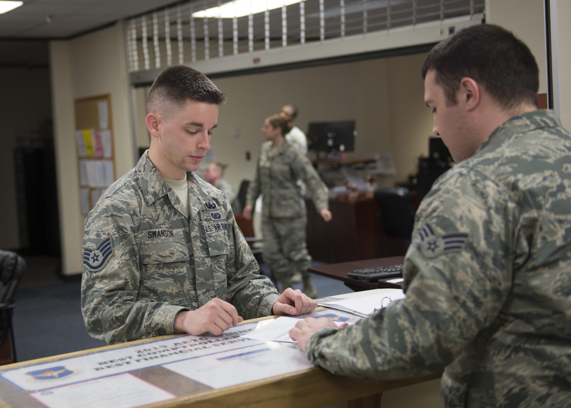 U.S. Air Force Staff Sgt. Taylor Swanson, 97th Comptroller Squadron financial services technician, aids a customer with questions about financial matters, Feb. 7, 2017, at Altus Air Force Base, Oklahoma. The 97th CPTS helps to maximize resources for the base and resolve financial issues for the Airmen on it. (U.S. Air Force Photo by Airman Jackson N. Haddon/Released).