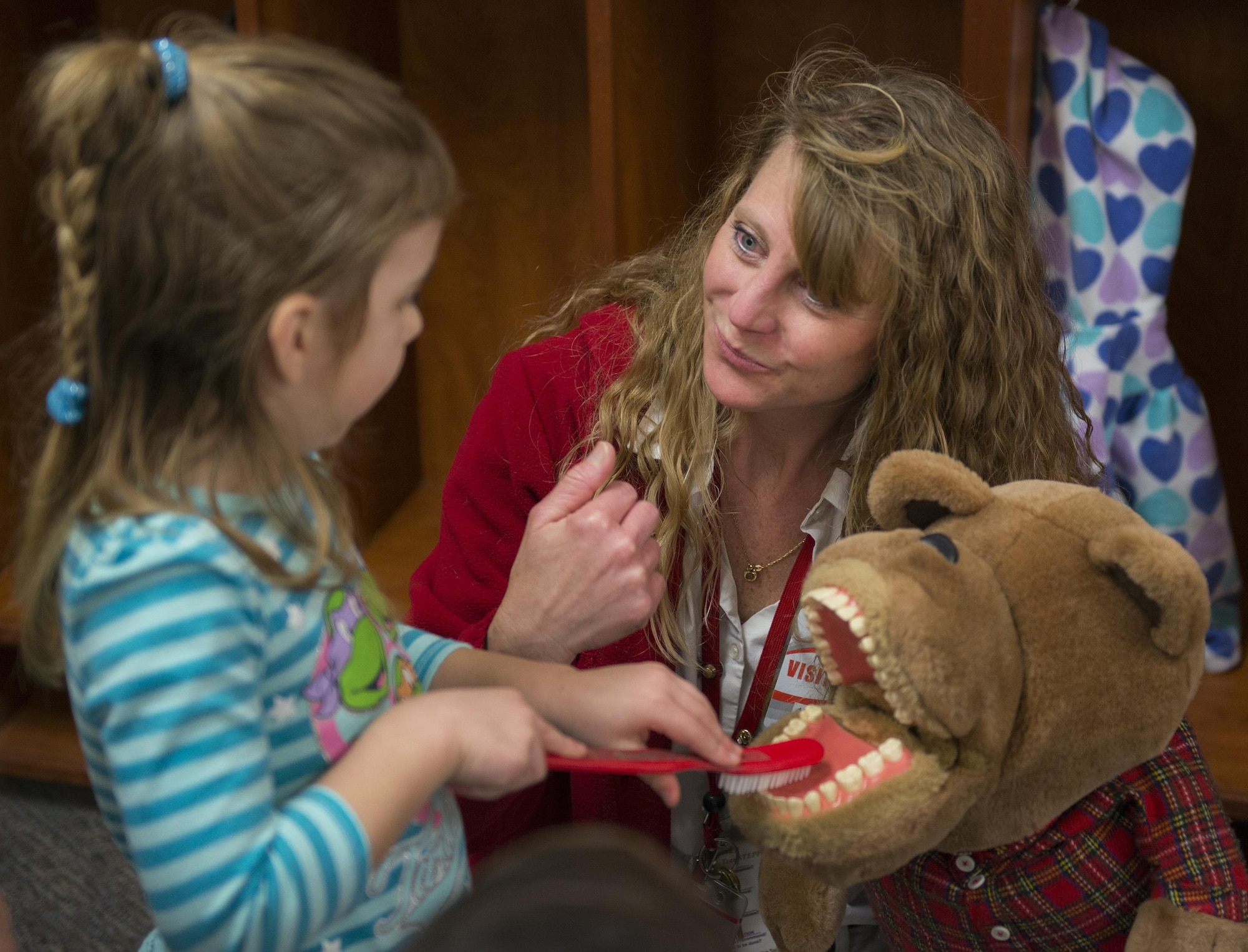 Monica Dunn instructs students on proper brushing technique using dental puppet and large tooth brush on Feb. 10, 2017. (US Air Force Photo/Sara Francis)