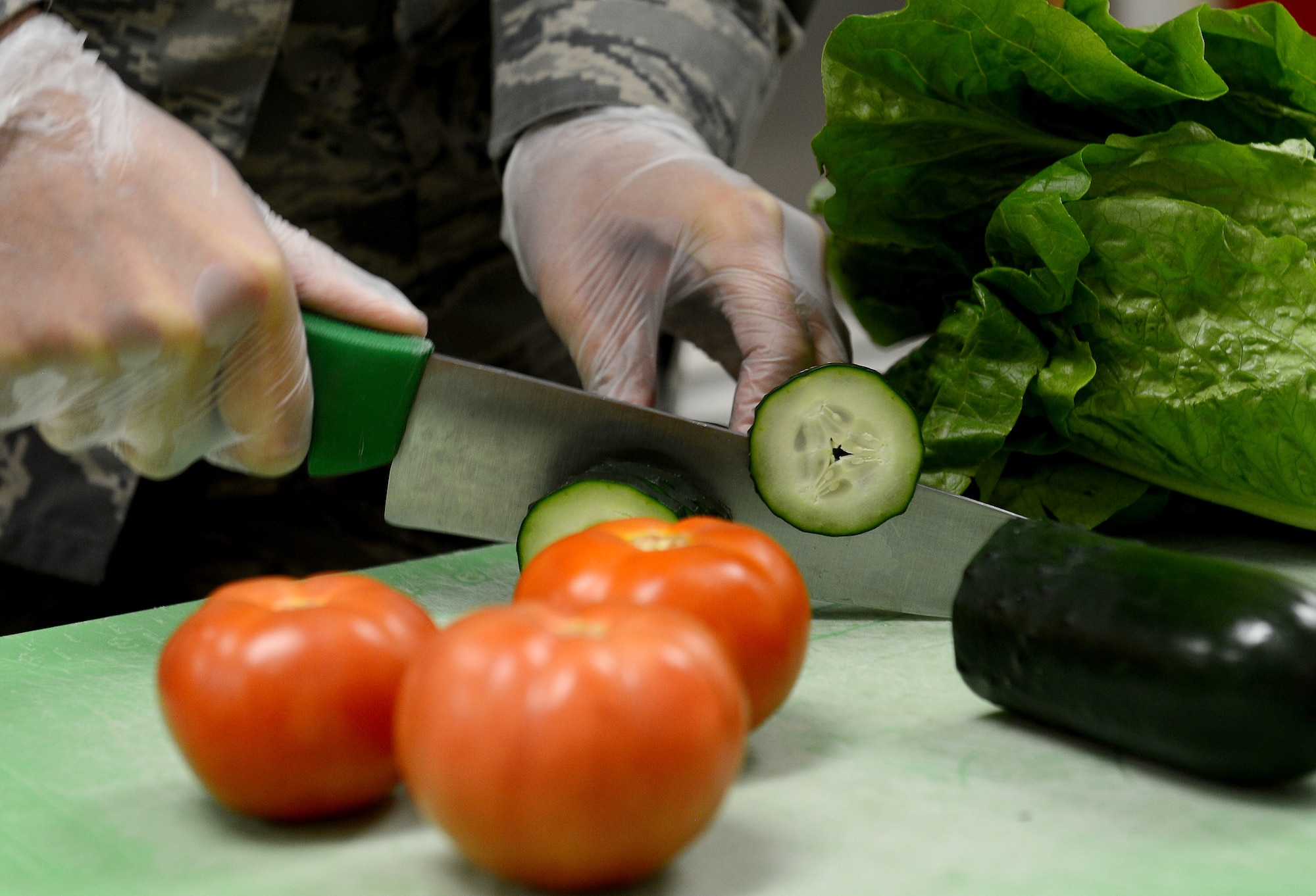 Airman 1st Class Arlena Harges, 627th Force Support Squadron food services apprentice, cuts vegetables for sandwiches and salads in the McChord flight kitchen Feb. 14, 2017 at Joint Base Lewis-McChord, Wash. The entrées for the boxed meals includes different types of sandwiches including turkey, ham and roast beef. They also have breaded chicken strips and a chef salad, as well as breakfast items. The supplemental options are often pre-contained food items such as chips, cookies, fresh fruit and your choice of beverage. (U.S. Air Force photo/Senior Airman Divine Cox)