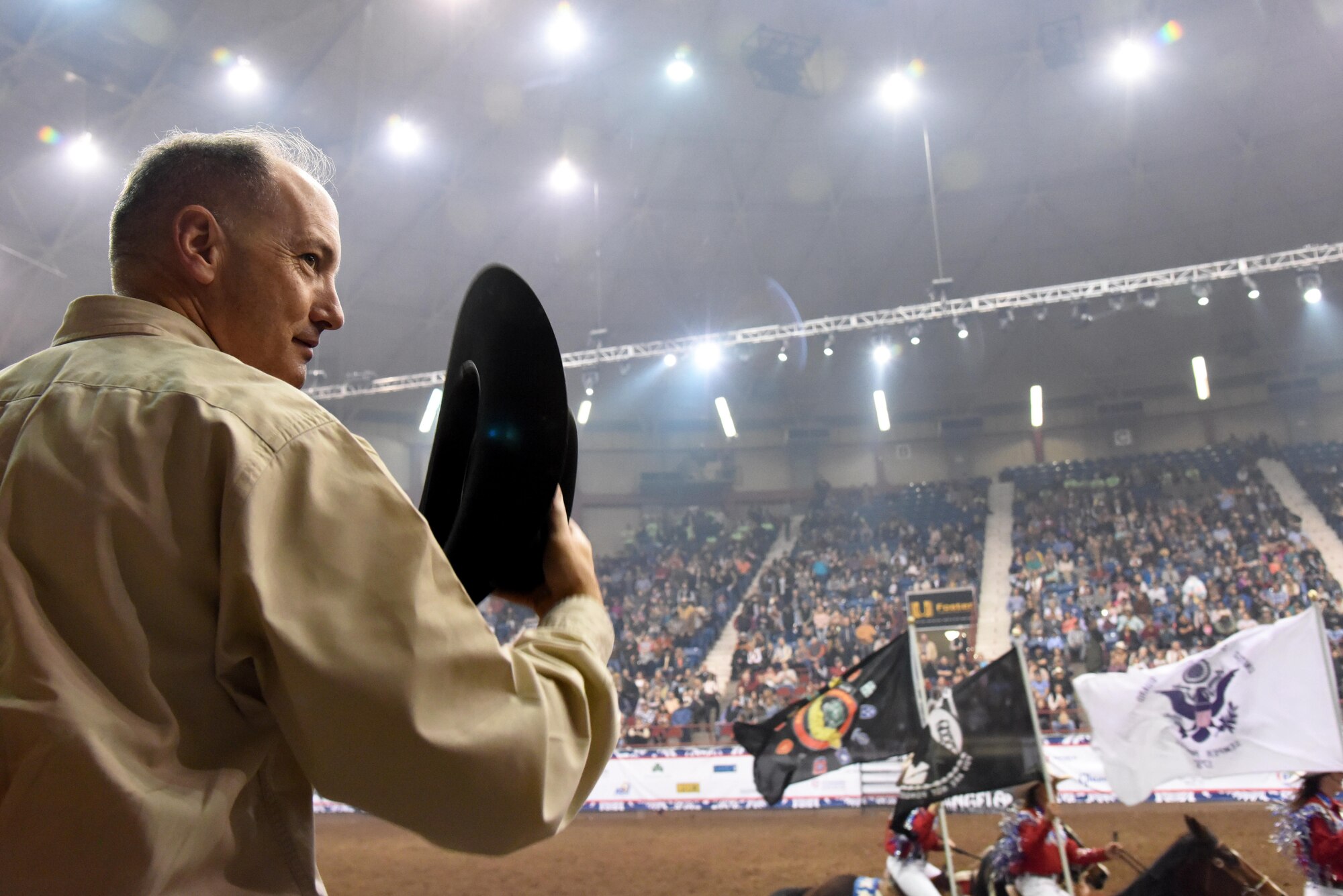 U.S. Air Force Col. Michael Downs, 17th Training Wing Commander, stands for passing of the colors during the 85th Annual San Angelo Stock Show and Rodeo Military Appreciation Night at the Foster Communications Coliseum in San Angelo, Texas, Feb. 15, 2017. The San Angelo Stock Show and Rodeo Ambassadors Drill Team provided a performance with the American flag, service member flags and other patriotic flags. (U.S. Air Force photo by Staff Sgt. Joshua Edwards/Released)