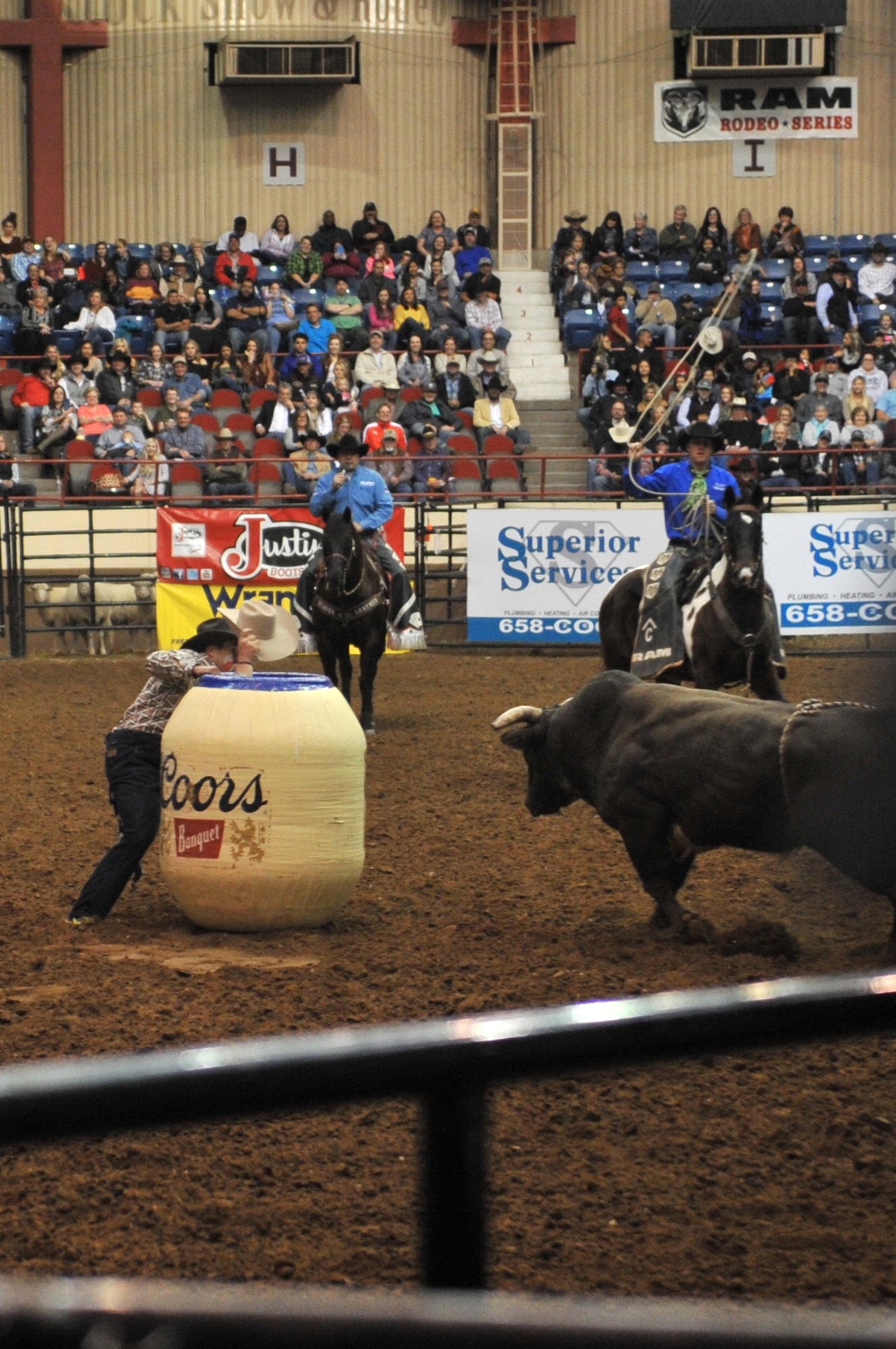 A bull gives the audience some additional entertainment during the 85th Annual San Angelo Stock Show and Rodeo Military Appreciation Night at the Foster Communications Coliseum in San Angelo, Texas, Feb. 15, 2017. Holding up the hat from inside the barrel is rodeo clown Justin Rumford. (U.S. Air Force photo by Staff Sgt. Laura R. McFarlane/Released)