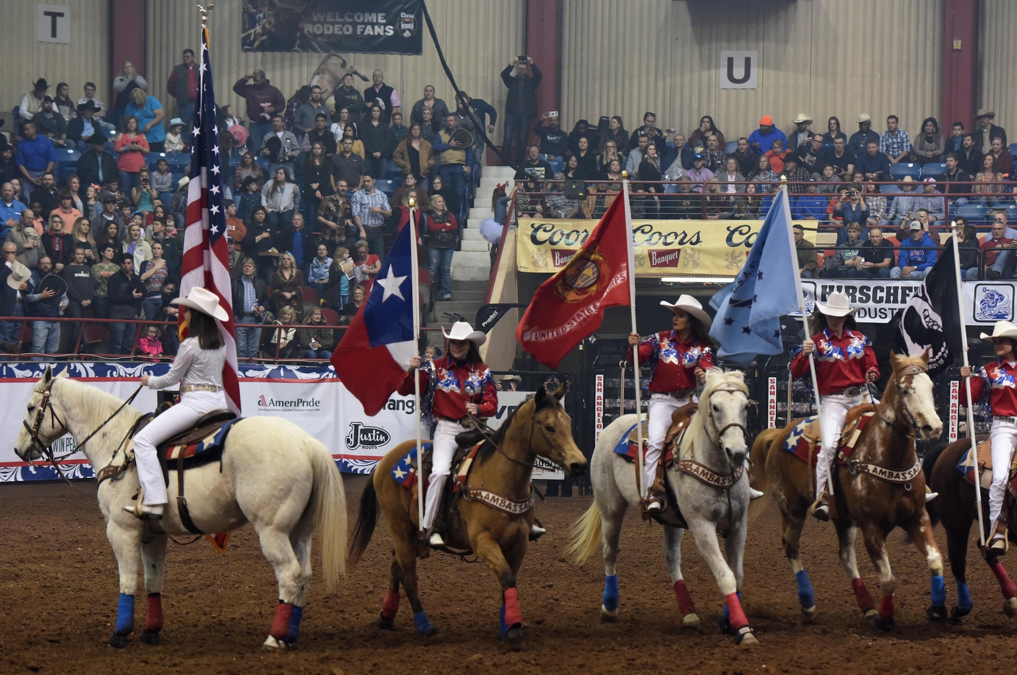 The San Angelo Stock Show and Rodeo Ambassadors Drill Team perform during the 85th Annual San Angelo Stock Show and Rodeo Military Appreciation Night at the Foster Communications Coliseum in San Angelo, Texas, Feb. 15, 2017. They carried patriotic flags during the drill. (U.S. Air Force photo by Staff Sgt. Laura R. McFarlane/Released)