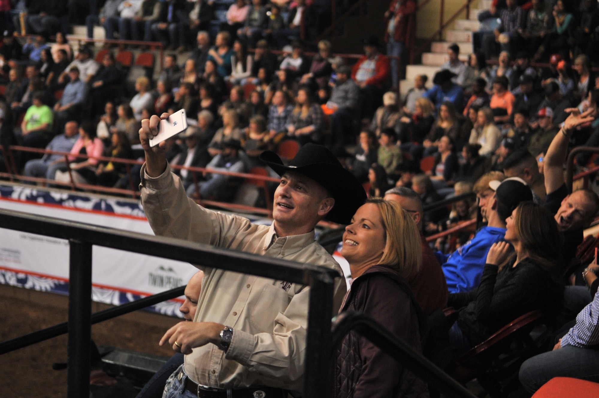 U.S. Air Force Col. Michael Downs, 17th Training Wing Commander, and Chief Master Sgt. Bobbie Riensche, 17th TRW Command Chief, take a selfie before the 85th Annual San Angelo Stock Show and Rodeo Military Appreciation Night at the Foster Communications Coliseum in San Angelo, Texas, Feb. 15, 2017. The rodeo honored military members with special presentations during the night. (U.S. Air Force photo by Staff Sgt. Laura R. McFarlane/Released)