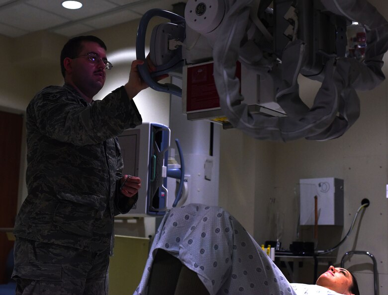 Staff Sgt. Jason Spearow, 341st Medical Support Squadron NCO in charge of diagnostic imaging, administers an x-ray in the control room Feb. 15, 2017, at Malmstrom Air Force Base, Mont. The x-ray tube Spearow pulls toward the patient and over the specific body part. (U.S. Air Force photo/Senior Airman Jaeda Tookes) 