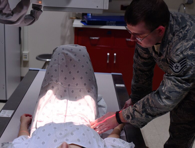Staff Sgt. Jason Spearow, 341st Medical Support Squadron NCO in charge of diagnostic imaging, administers an x-ray in the control room Feb. 15, 2017, at Malmstrom Air Force Base, Mont. It is critical for technicians to verify and photograph the correct body part in the diagnostic image to produce the cleanest, sharpest image for the radiologist to diagnose. (U.S. Air Force photo/Senior Airman Jaeda Tookes)