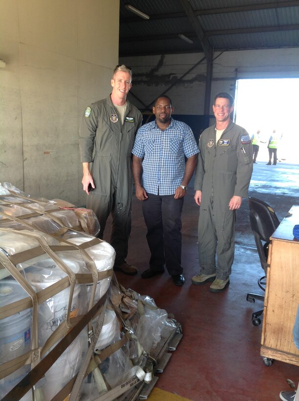1st Lt. William Thompson and Maj. Quentin Mueller, pilots with the 77th Air Refueling Squadron, stand with a St. Lucia aid worker during their humanitarian mission to the small island country in January. The Denton Program shipment benefitted St. Lucia’s main hospital, one health clinic, two schools and four nursing homes. (U.S. Air Force courtesy photo)
