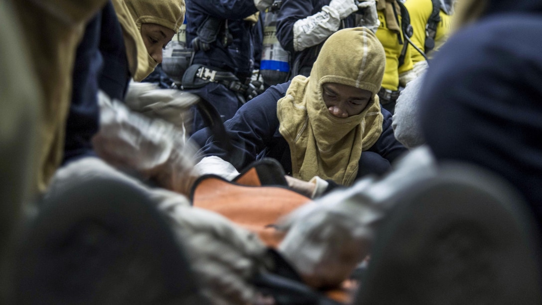 Sailors treat a simulated personnel casualty in the hangar bay of the aircraft carrier USS Dwight D. Eisenhower during a general quarters drill in the Pacific Ocean, Feb. 14, 2017. The ship is conducting aircraft carrier qualifications. Navy photo by Petty Officer 3rd Class Nathan T. Beard