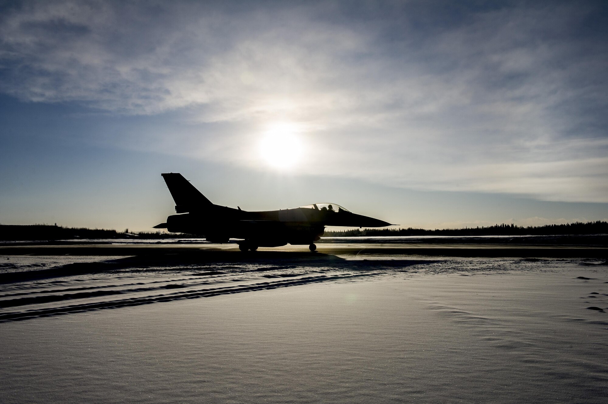 A U.S. Air Force F-16 Fighting Falcon aircraft assigned to the 18th Aggressor Squadron, waits on the taxi-way Feb. 12, 2017, at Eielson Air Force Base, Alaska. The aircraft was part of the group that deployed to Andersen Air Force Base, Guam, in support of COPE NORTH 2017, an exercise designed to increase combat readiness among coalition forces. (U.S. Air Force photo by Airman Isaac Johnson)