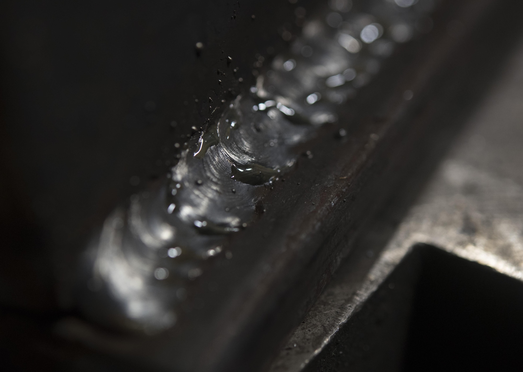 Slag sits on a steel bar at Misawa Air Base, Japan, Feb. 1, 2017. Slag consists of all the impurities left over from heated metal. Airmen scrub away the substance with a wire brush and make final touches on the weld if needed. (U.S. Air Force photo by Airman 1st Class Sadie Colbert)