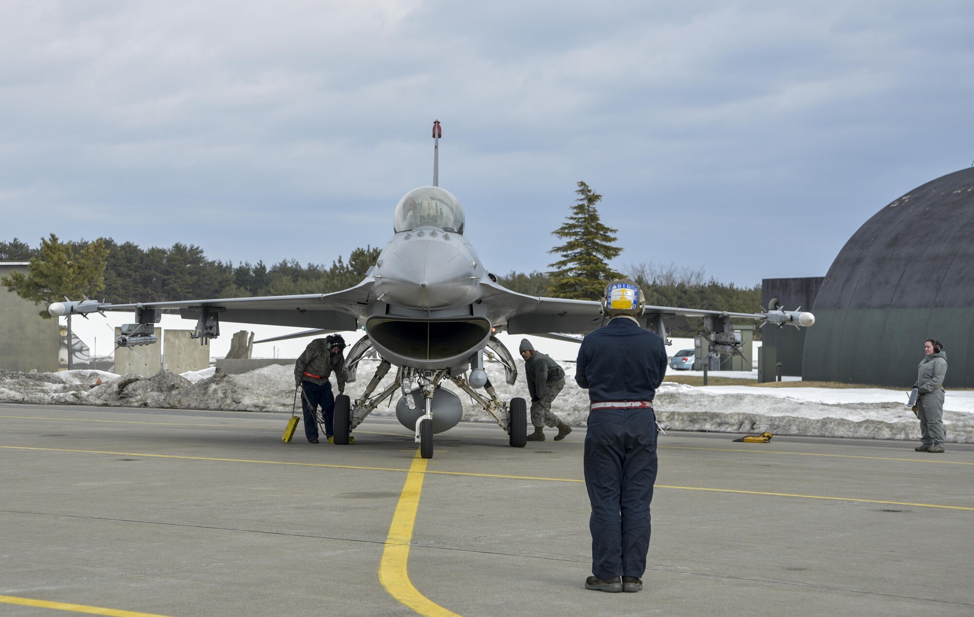 U.S. Air Force Senior Airman Jose Rosales, a dedicated crew chief with the 13th Fighter Squadron, taxies an F-16 Fighting Falcon at Misawa Air Base, Japan, Feb. 16, 2017. The 13th FS flies 36 sorties a day during a three-day surge. Airmen work around the clock to increase mission capabilities to provide worldwide deployable forces while defending Japan with U.S. forward presence. (U.S. Air Force photo by Staff Sgt. Melanie Hutto)
