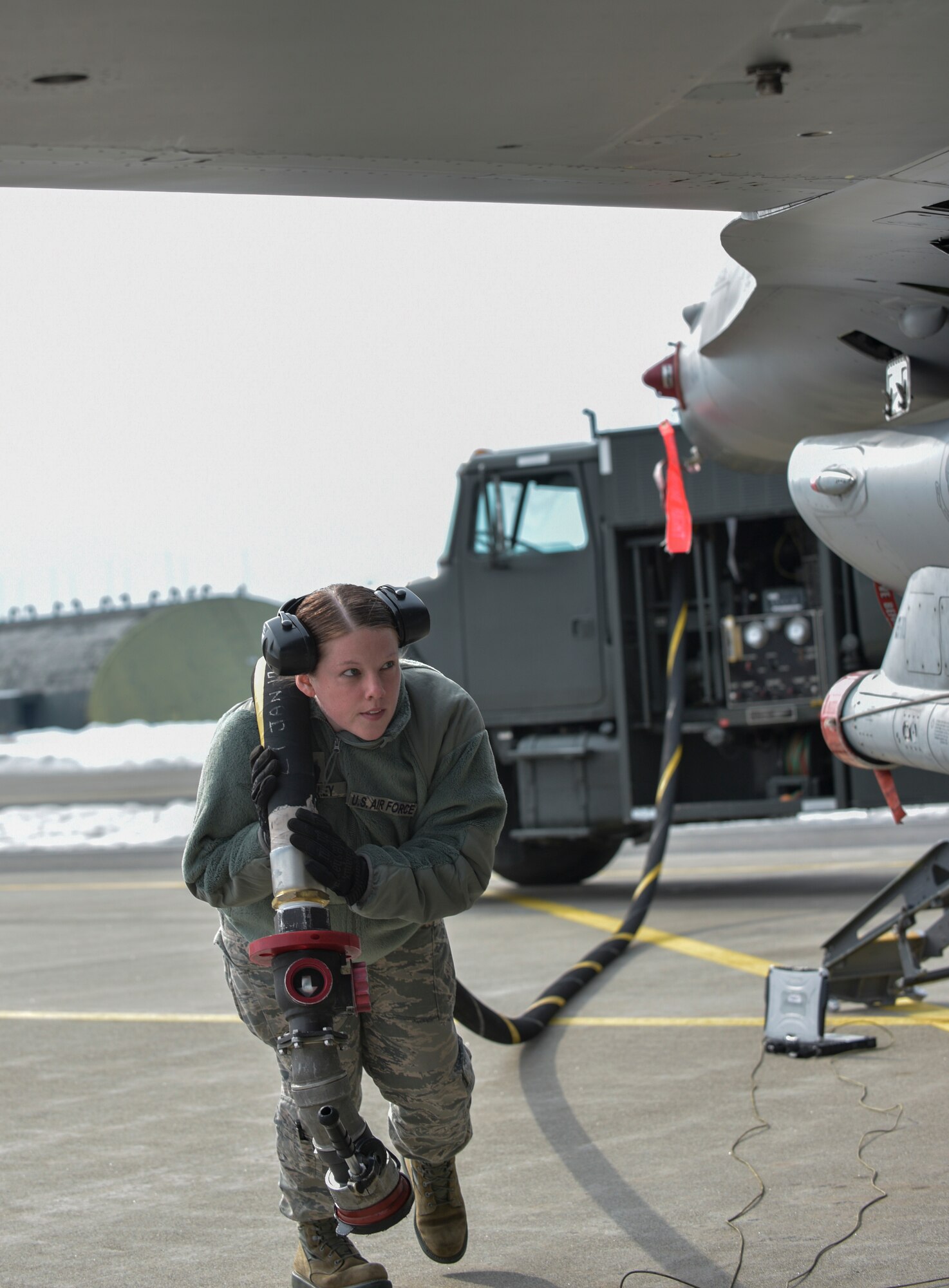 U.S. Air Force Staff Sgt. Lacey Crowley, a fuels distribution supervisor with the 35th Logistics Readiness Squadron, carries a fuel hose at Misawa Air Base, Japan, Feb. 16, 2017. Crowley fueled F-16 Fighting Falcons throughout the week while the 13th Fighter Squadron took part in a three-day surge. During the event, Airmen generated 36 sorties a day for mission deployment, continuing the mission despite the 14th Fighter Squadron currently deployed to COPE NORTH 17. (U.S. Air Force photo by Staff Sgt. Melanie Hutto)
