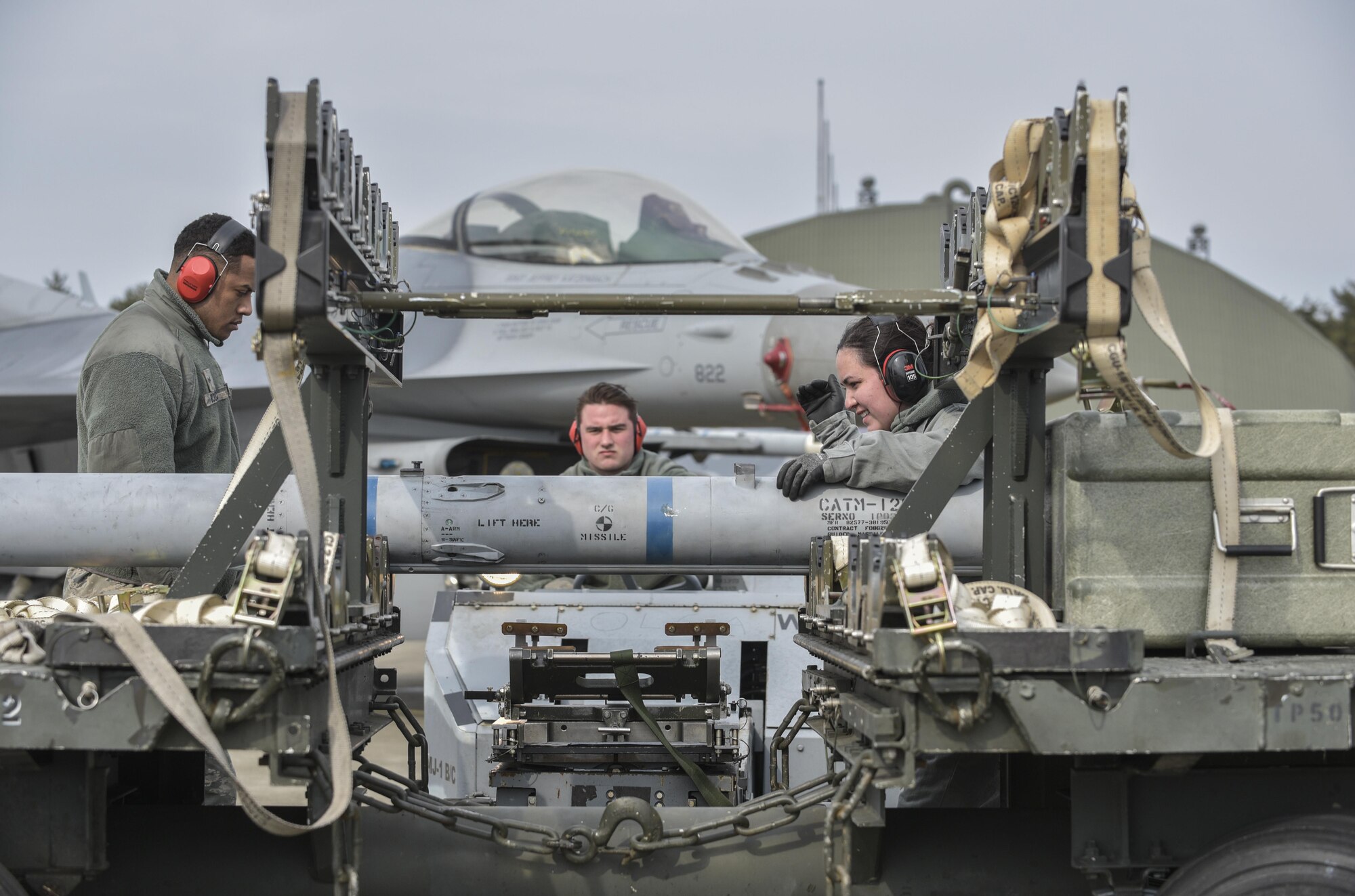U.S. Air Force Staff Sgt. Zion Monica, right, a weapons load crew chief with the 14th Aircraft Maintenance Unit, and Senior Airman Anthony Molero, left, a weapons load crew member with the 14th AMU, guides an AIM-120 advanced medium range air-to-air missile onto an F-16 Fighting Falcon at Misawa Air Base, Japan, Feb. 16, 2017. Airmen work 12-hour shifts to ensure mission capabilities are met during a three-day surge. (U.S. Air Force photo by Staff Sgt. Melanie Hutto)
