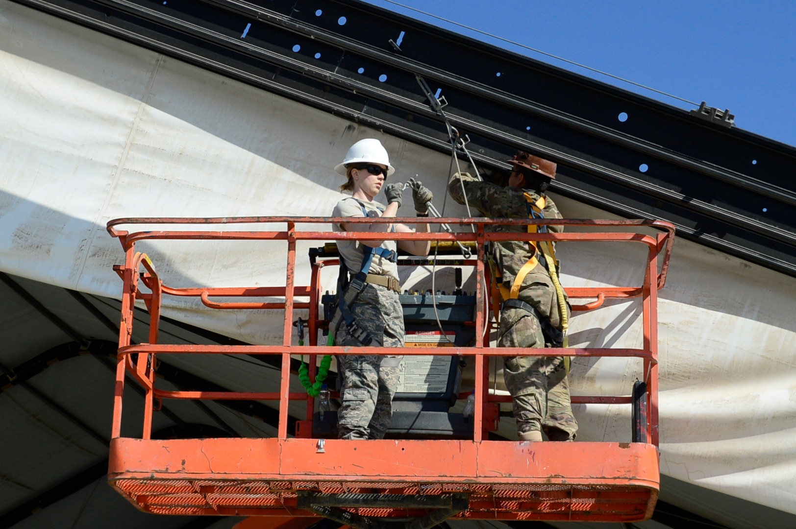 U.S. Air Force Capt. Silvey Hollenback, 386th Expeditionary Civil Engineer Squadron chief of operations engineering, center, and Senior Airman Steven Medina, 557th Expeditionary Prime BEEF Squadron electrician, right, deconstruct a large aircraft maintenance shelter at an undisclosed location in Southwest Asia, Feb. 8, 2017. The LAMS was being torn down in order to make room for the 386th Air Expeditionary Wing to house a fleet of MQ-9 Reapers. (U.S. Air Force photo by Capt. Casey Osborne)