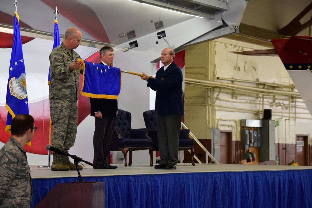 12th Flying Training Wing Commander, Col. Joel Carey unfurls the 12th Maintenance Group's organizational flag with the group's director, Robert West and the the group's deputy director Robert Hamm during an activation ceremony Feb. 10 at Joint Base San Antonio - Randolph, Texas.  The group is the first civil service maintenance directorate in Air Education and Training Command to reorganize as a group.  (U.S. Air Force photo by Randy Martin) 