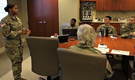 Capt. Katrina Bennett, from the North Regional Capital Cyber Protection Center, presents readiness data to Maj. Gen. Pete Bosse, commanding general, for the 335th Signal Command (Theater), and Col. Michael D. Smith, commander of the U.S. Army Reserve Cyber Operations Group, 335th SC (T) and other senior leaders and staff during a command brief, Jan 7 at the ARCOG headquarters in Adelphi, Maryland. The purpose was for the Bosse to review and give feedback on the readiness and training status for the ARCOG. (U.S. Army Reserve Photo by Sgt. Erick Yates)