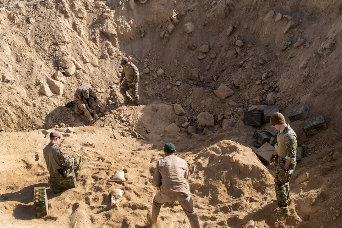 Air Force and Marine Corps explosive ordnance disposal technicians prepare a hole for a range detonation in Southwest Asia, Feb. 11, 2017. These technicians respond to in-flight emergencies and properly dispose of hazardous or unserviceable explosives and ammunition. Air Force photo by Staff Sgt. Eboni Reams