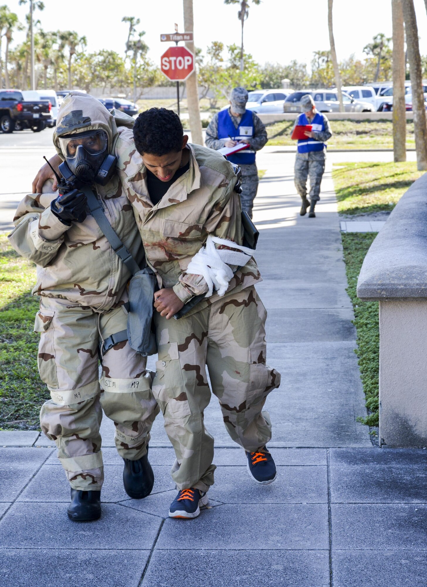Staff Sgt. Tonya Bass of the 920th Mission Support Group helps an injured Airman to safety in a simulated chemically contaminated environment while 920th Rescue Wing Inspector General Inspections team members evaluate her during the wing’s Mission Assurance Exercise Feb. 12 at Patrick Air Force Base, Fla. (U.S. Air Force photo/Senior Airman Brandon Kalloo Sanes)