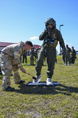 A 920th Rescue Wing Airman washes the boots of an aircrew member processing through the  aircrew contamination control area during the wing’s Mission Assurance Exercise Feb. 12 at Patrick Air Force Base, Fla. (U.S. Air Force photo/Senior Airman Brandon Kalloo Sanes)

